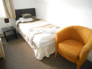 um quarto com uma cama e uma cadeira em Yarm View Cottages em Yarm