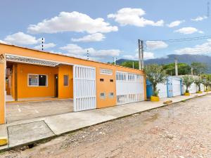 an orange building with white doors on a street at Residencial JL Maresias in Maresias