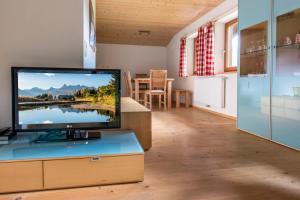 sala de estar con TV de pantalla plana sobre una mesa en Haus Silberberg, en Bartholomäberg