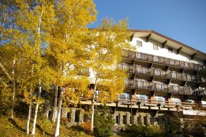 an apartment building with trees in front of it at Hotel Kodama in Yamanouchi