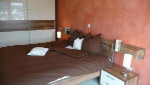 ein Schlafzimmer mit einem großen Bett mit brauner Bettwäsche und Kissen in der Unterkunft Kleines Ritz in Willingen
