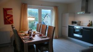 einen Esstisch mit Stühlen und eine Küche mit Fenster in der Unterkunft Kleines Ritz in Willingen