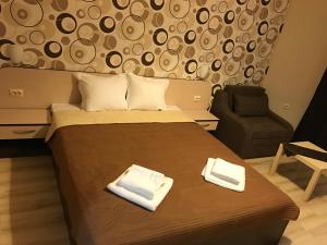 a bedroom with a bed with two towels on it at Hotel Body M in Vratsa