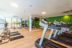 a gym with exercise equipment and green walls at Beach Class Convention By Mai in Recife