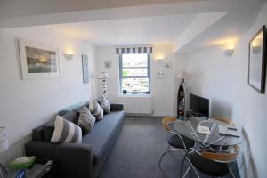 ein Wohnzimmer mit einem Sofa und einem Tisch in der Unterkunft One Fisherman's Loft in Brixham