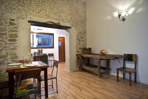 a dining room with a table and a stone wall at Residenza d'Epoca Borgodifiume in Fiumefreddo Bruzio
