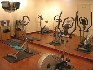 - une salle de sport avec plusieurs vélos d'exercice et un miroir dans l'établissement Auberge De Bourgogne, à Tonnerre