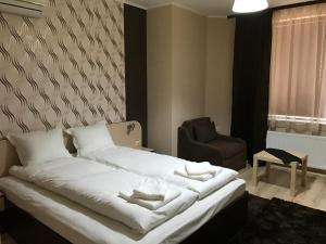 Vratsa的住宿－Hotel Body M，卧室配有白色的床和椅子