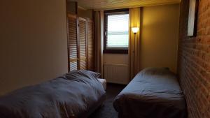 a small bedroom with two beds and a window at Vakantiewoning Kleijnen in Noorbeek