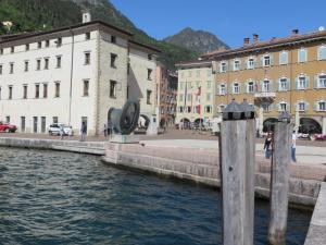 un grupo de edificios junto a una masa de agua en Al Lago Apartments, en Riva del Garda