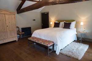 米德漢的住宿－The Priory，卧室设有一张白色大床和木地板