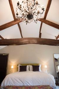 a bedroom with a white bed with a chandelier at The Priory in Middleham