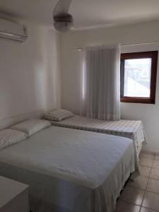 a bedroom with two beds and a window at Casa de Luxo com 3 Suites no Condominio Horizonte da Serra 1 em Gravatá in Gravatá