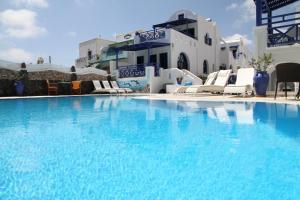 a large blue swimming pool with chairs and buildings at Samson΄s Village in Perissa