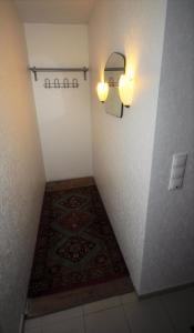 einen Flur mit einem Teppich und einem Licht an der Wand in der Unterkunft Haus Rebstock in Bornheim