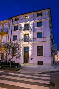 a white building with a car parked in front of it at Apartments Villa Castello in Crikvenica