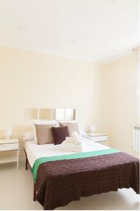 a white bedroom with a large bed with pillows at For You Rentals parque del retiro apartment TEMPORAL LDR28 in Madrid