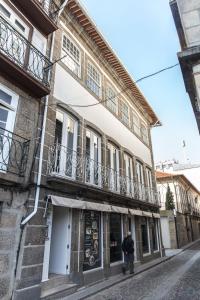 un hombre caminando por una calle en frente de un edificio en TM Guest House, en Guimarães