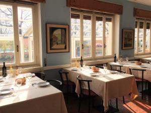 a dining room with white tables and windows at Camping Hotel Au Lac De Como in Sorico