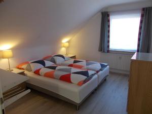 a bedroom with a bed and two lamps and a window at Apartment Seven Ducks in Aalen