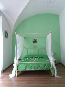 una camera verde con un letto a baldacchino di B&B Favola Mediterranea a Catania