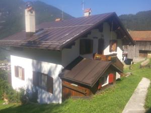 a house with a metal roof on top of it at Casa Alpina in Cencenighe