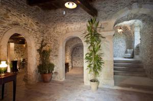 a room with a stone wall and some plants at Residenza d'Epoca Borgodifiume in Fiumefreddo Bruzio