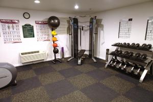 a gym with weights and equipment in a room at Arden Star Hotel in Sacramento