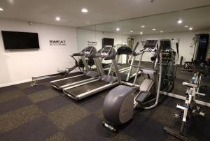a gym with several tread machines and a flat screen tv at Arden Star Hotel in Sacramento
