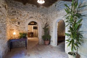 a stone hallway with a table and potted plants at Residenza d'Epoca Borgodifiume in Fiumefreddo Bruzio