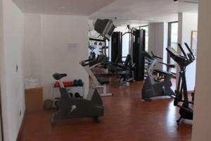 un gimnasio con varias máquinas de cardio en una habitación en La Gloria 30. Las Condes, en Santiago