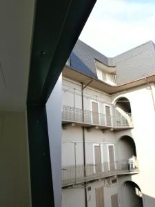 セレーニョにあるAppartamento Galileoのバルコニー付きの建物の側面の景色を望めます。