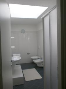 Baño blanco con 2 aseos y tragaluz en Appartamento Galileo, en Seregno