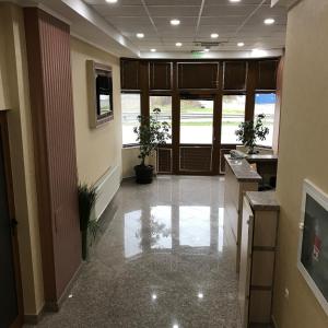 an office lobby with a hallway with plants in it at Hotel Body M in Vratsa