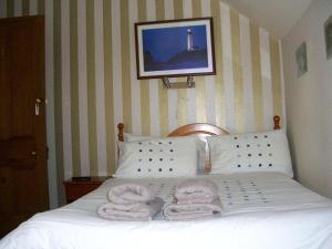 a bedroom with a bed with towels on it at The Quaich B&B in Inverness