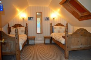 a bedroom with two beds and a mirror at The Quaich B&B in Inverness