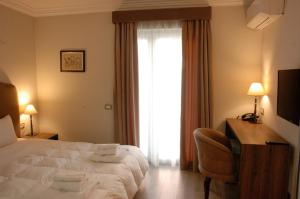 A bed or beds in a room at Hotel Hermes Tirana