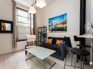a living room with a couch and a table at Divi Apartments Valvanera in Seville