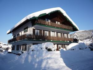 a building covered in snow with snow around it at Pension Bergblick in Ruhpolding