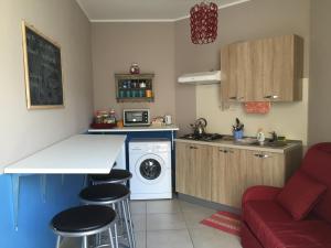 アルバにあるラ カセッタの小さなキッチン(洗濯機、赤いソファ付)