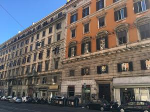 un grande edificio con macchine parcheggiate di fronte di Favola Romana - Guest House a Roma