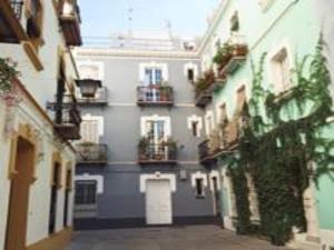 a building with balconies on the side of a street at Divi Apartments Valvanera in Seville