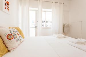 Un dormitorio blanco con una cama blanca y una ventana en FLH Marques Bright Apartment, en Lisboa