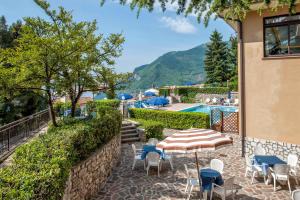 a patio with chairs and tables and a swimming pool at Hotel Bellavista in Tignale