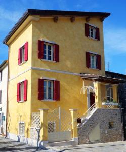 un edificio amarillo con persianas rojas. en House Versilia Luca E Giada, 5 chilometri da Forte dei Marmi! en Forte dei Marmi