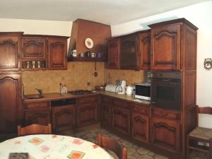 uma cozinha com armários de madeira e uma mesa em Villa Style Provencal em Gignac-la-Nerthe