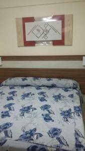 Un dormitorio con una cama con flores azules. en Via Caldas L'acqua V, en Caldas Novas