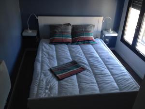 a large white bed with two pillows on it at Oléron in Saint-Denis-dʼOléron