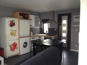a kitchen with a table and a refrigerator and a stove at Oléron in Saint-Denis-dʼOléron