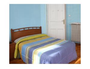 Cama en habitación con pared azul en Hostal Bayón en León